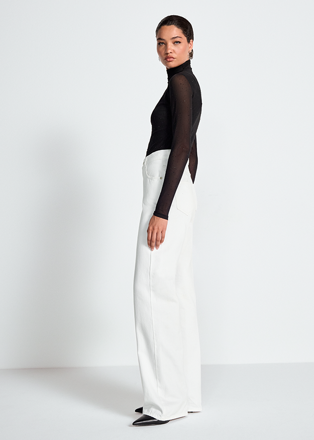 schwarzer Rollkragenpullover, transparente Ärmel, Punktmuster, weiße Hose