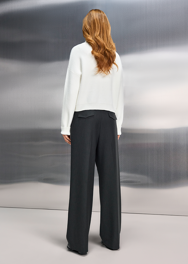 weißes sweater, lange Ärmel, gelegtes Stricktop, schwarze weite Hose, Rückansicht