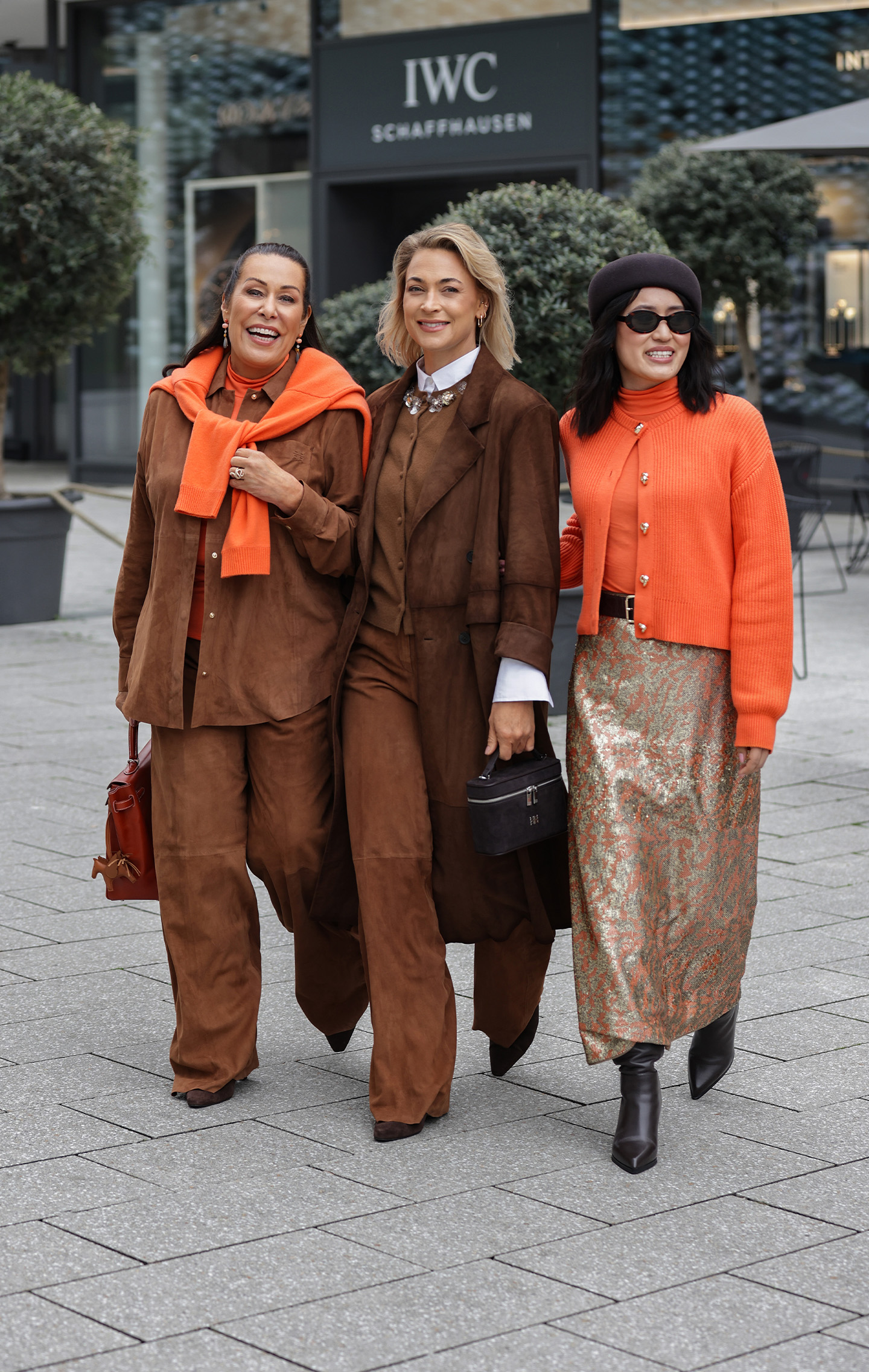 orange scarf, brown suit, brown coat, orange cardigan, black handbag